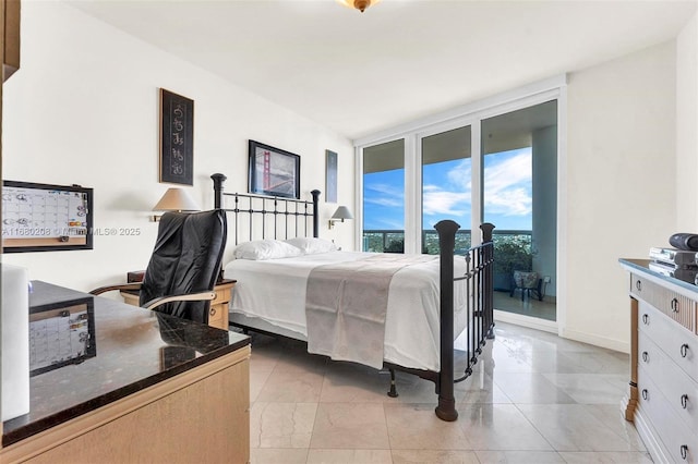 bedroom with access to exterior, expansive windows, and baseboards