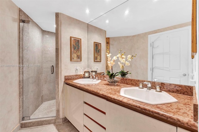 bathroom featuring a sink, a shower stall, and double vanity