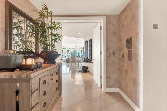 hallway featuring baseboards and light tile patterned floors