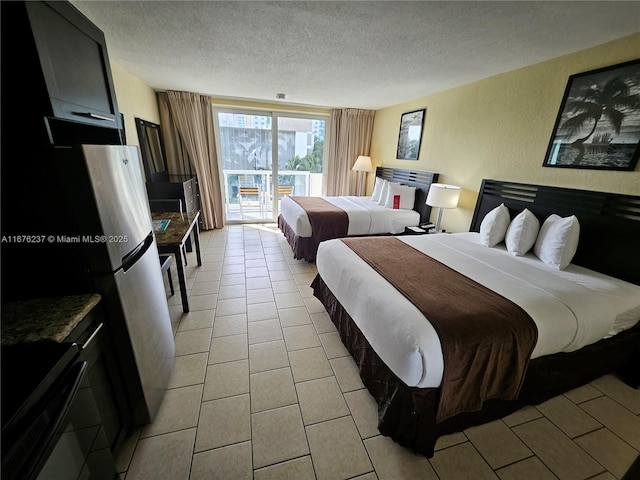 bedroom featuring access to outside, light tile patterned flooring, a textured wall, and a textured ceiling