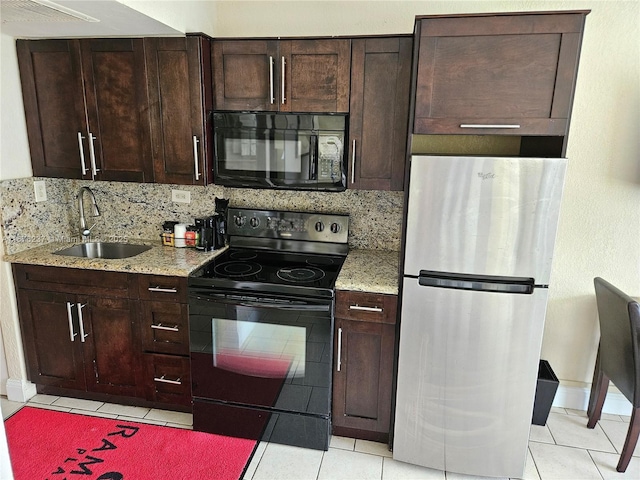 kitchen with dark brown cabinetry, tasteful backsplash, light tile patterned floors, black appliances, and a sink