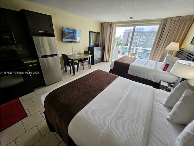 bedroom with access to exterior, freestanding refrigerator, a textured ceiling, and light tile patterned floors