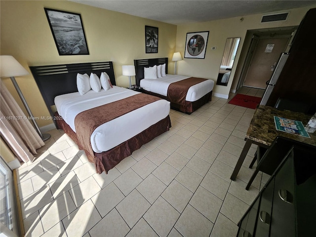 bedroom featuring visible vents, baseboards, and light tile patterned floors