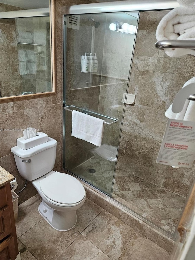 bathroom with toilet, a shower stall, and vanity