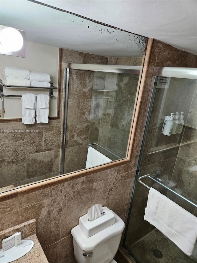 full bathroom with a shower stall and tile walls