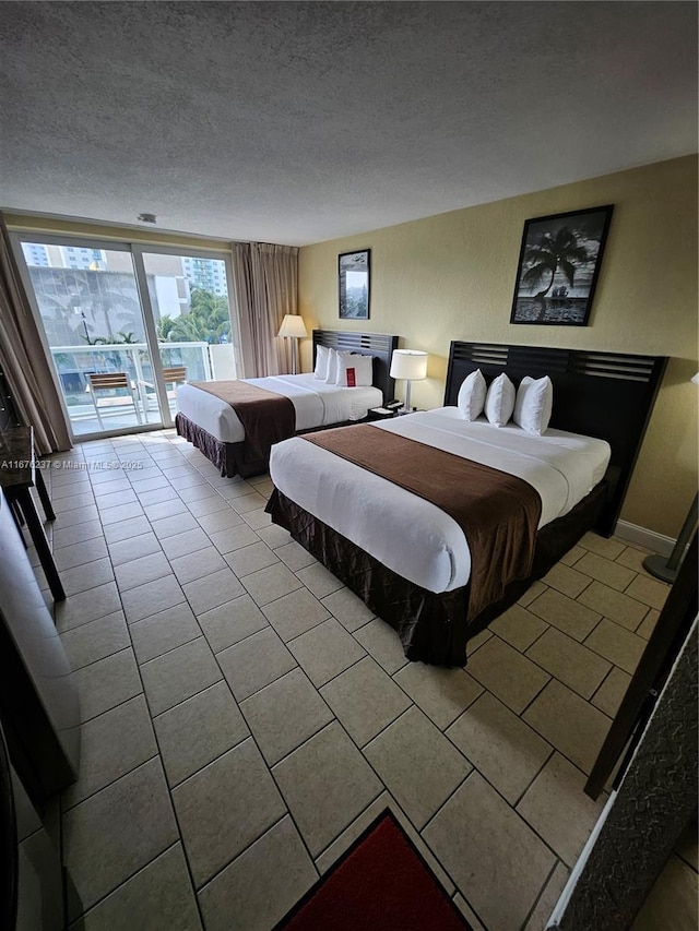 bedroom with access to exterior, baseboards, and a textured ceiling