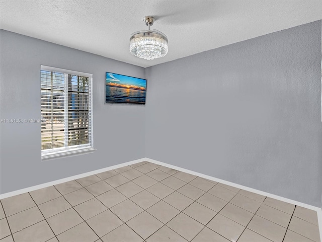 spare room featuring a textured ceiling and light tile patterned flooring