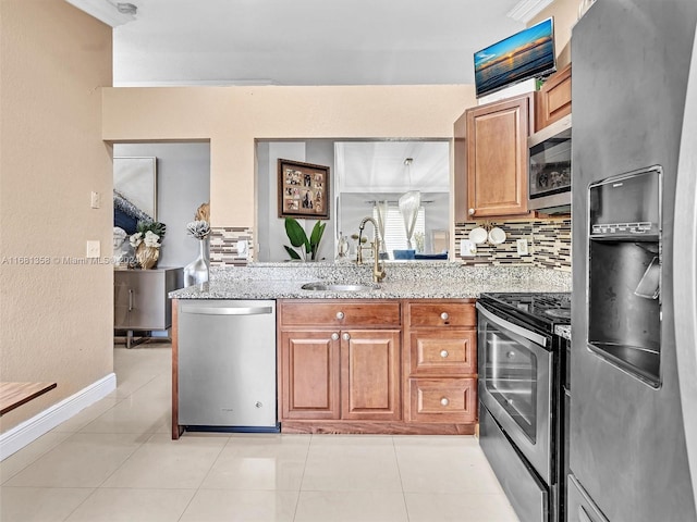 kitchen featuring decorative backsplash, light stone counters, appliances with stainless steel finishes, light tile patterned flooring, and sink