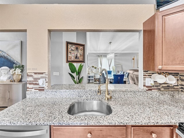 kitchen with sink, light stone counters, and backsplash