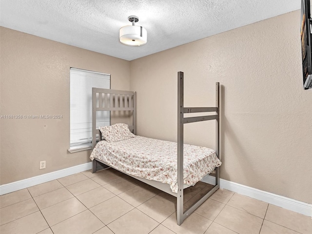 bedroom featuring a textured ceiling and light tile patterned floors