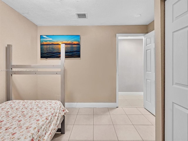 tiled bedroom featuring a textured ceiling