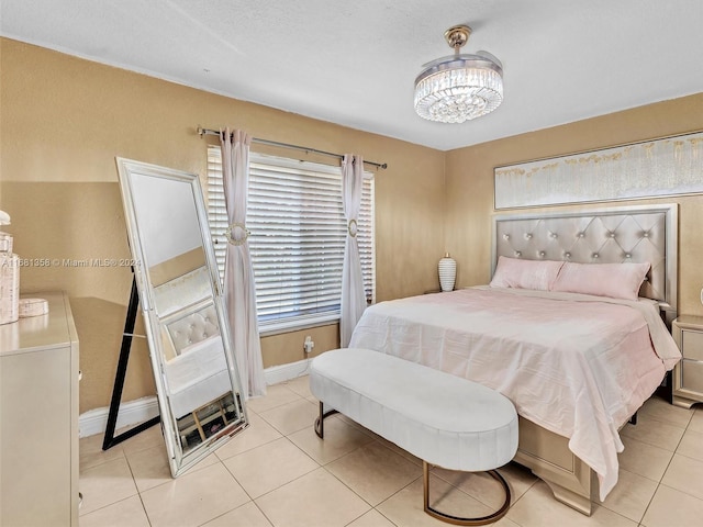 tiled bedroom featuring an inviting chandelier