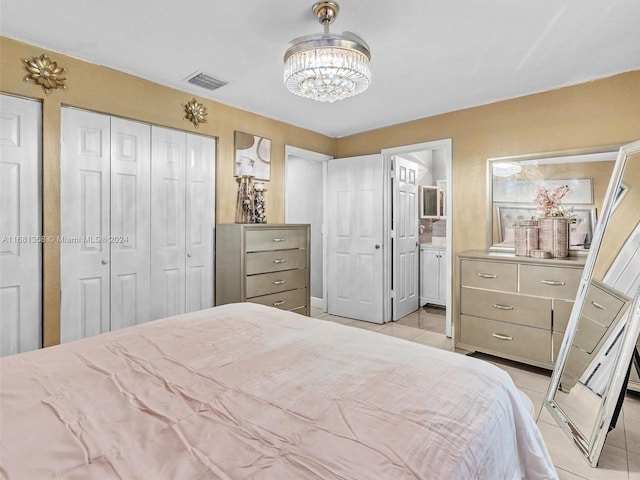 bedroom with connected bathroom, a notable chandelier, and light tile patterned floors