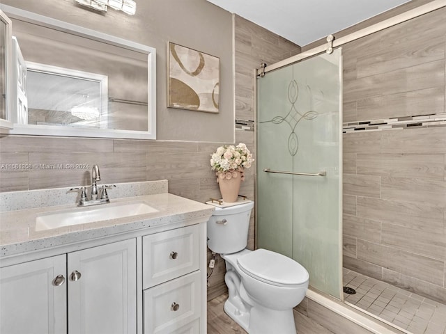 bathroom featuring vanity, toilet, tile walls, and an enclosed shower