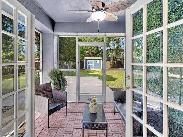 unfurnished sunroom with ceiling fan