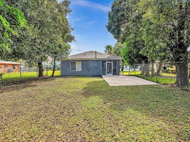 back of house featuring a patio area and a yard