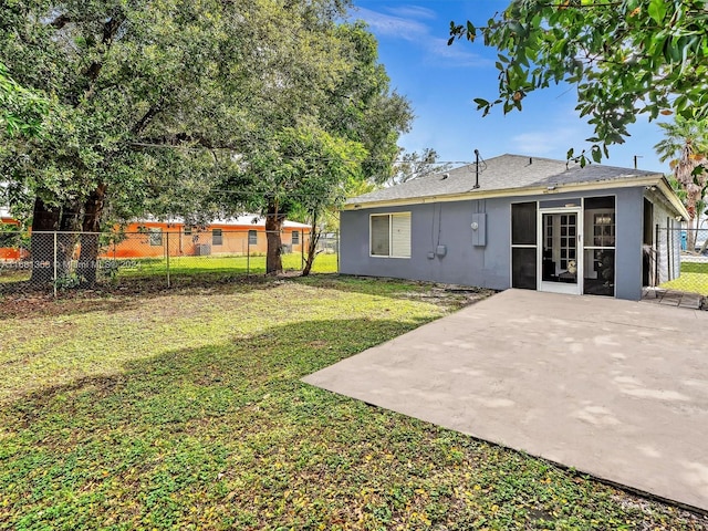 rear view of house with a patio area and a lawn