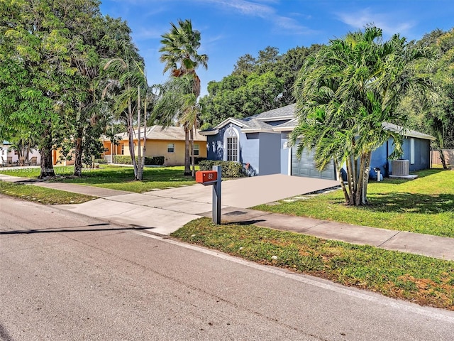 ranch-style home with a front yard, central AC, and a garage