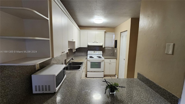 kitchen with a textured ceiling, white electric stove, sink, and white cabinets