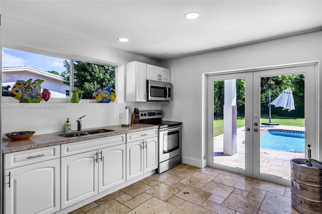 kitchen featuring french doors, appliances with stainless steel finishes, sink, and white cabinets