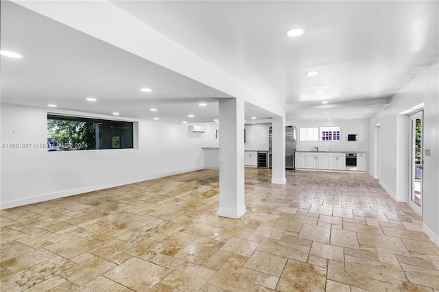 basement with stainless steel refrigerator and sink