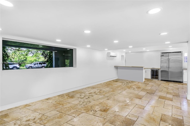 basement with beverage cooler, an AC wall unit, and high end refrigerator