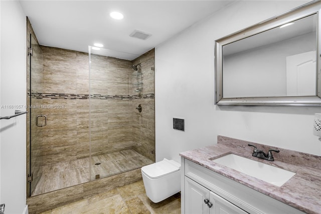 bathroom with vanity, a shower with shower door, and toilet