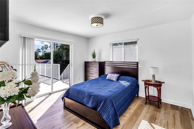 bedroom with access to exterior, multiple windows, and light hardwood / wood-style floors