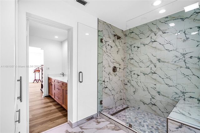 bathroom with a shower with door, vanity, and hardwood / wood-style floors