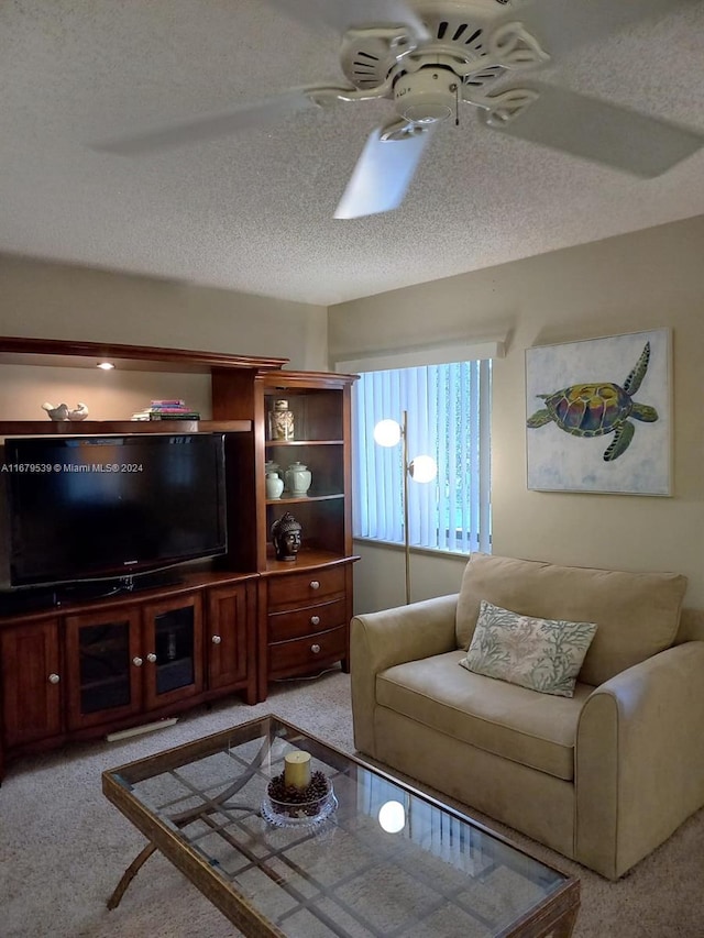 carpeted living room with a textured ceiling and ceiling fan