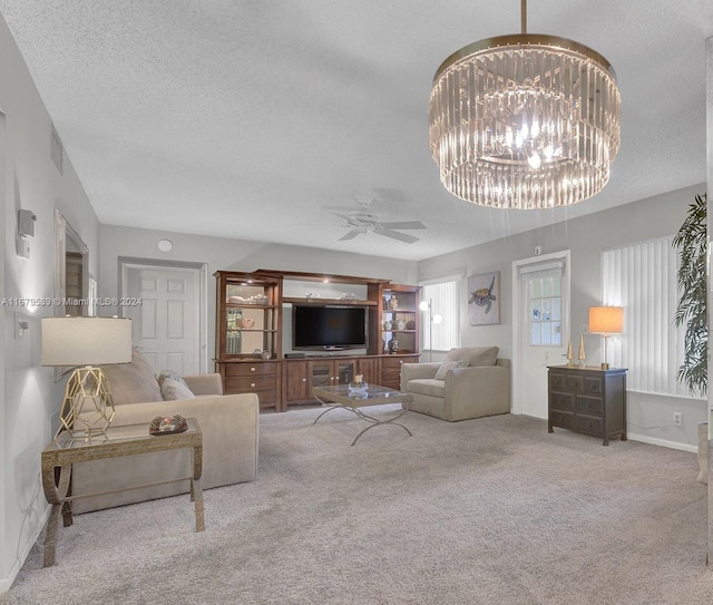 carpeted living room with a textured ceiling and ceiling fan with notable chandelier