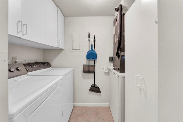 laundry area with washer and clothes dryer, cabinets, electric panel, a barn door, and light tile patterned flooring