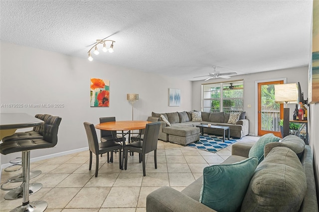 living room featuring ceiling fan, light tile patterned flooring, and a textured ceiling