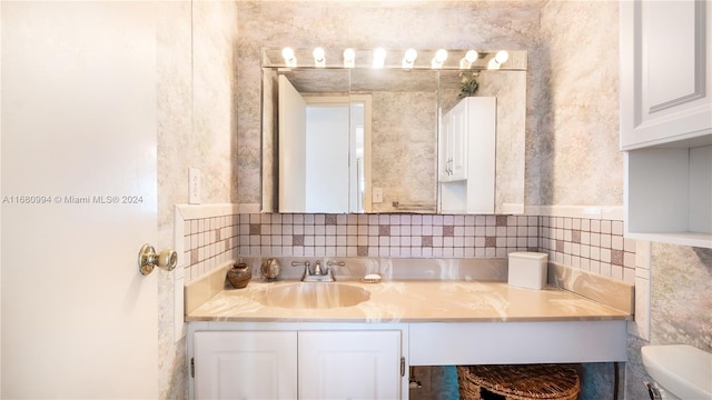 bathroom featuring vanity, toilet, and tasteful backsplash