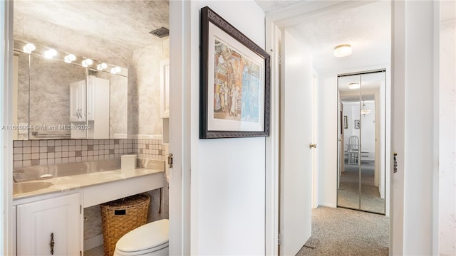 bathroom with vanity, a textured ceiling, and toilet