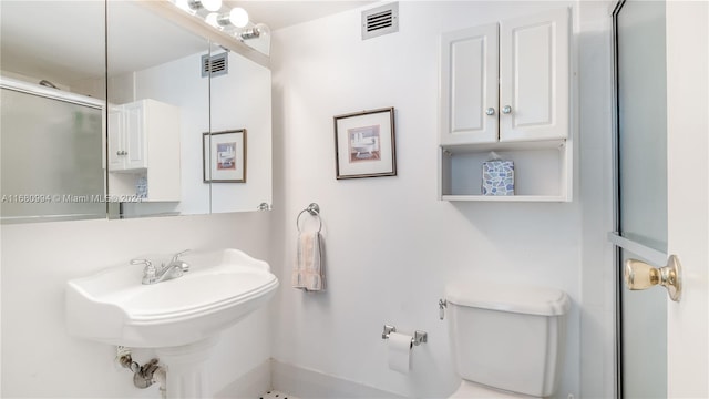 bathroom with toilet and an enclosed shower