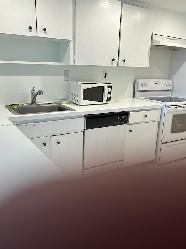 kitchen featuring range hood, sink, white cabinets, and white appliances