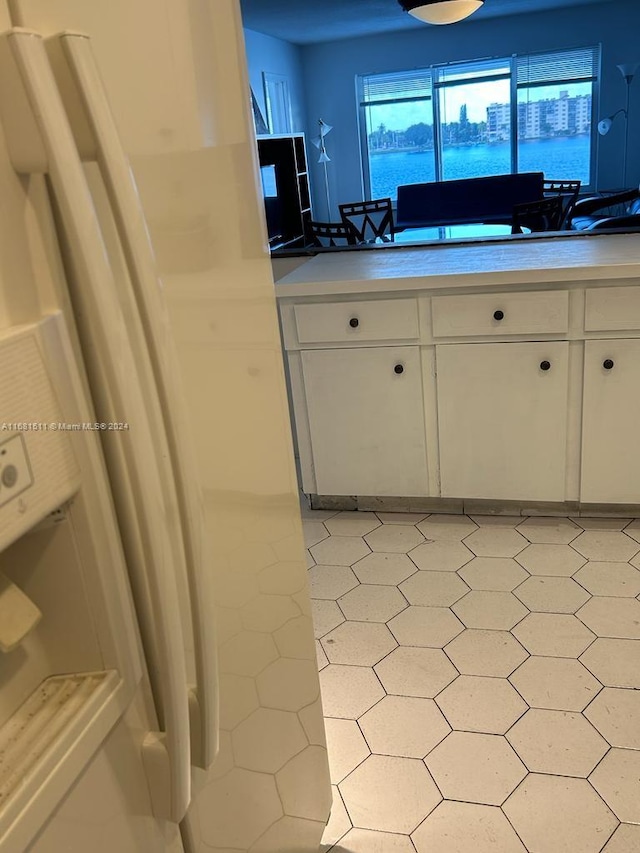 kitchen featuring white cabinets and white fridge