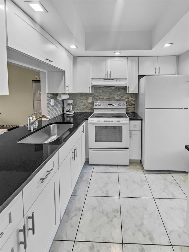 kitchen featuring sink, a raised ceiling, white cabinets, white appliances, and tasteful backsplash