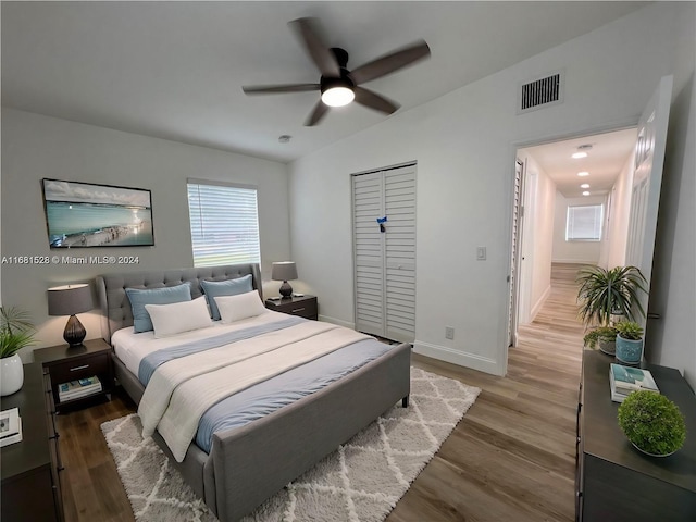 bedroom with a closet, ceiling fan, hardwood / wood-style floors, and lofted ceiling