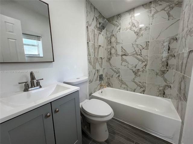 full bathroom with vanity, tiled shower / bath combo, hardwood / wood-style flooring, and toilet