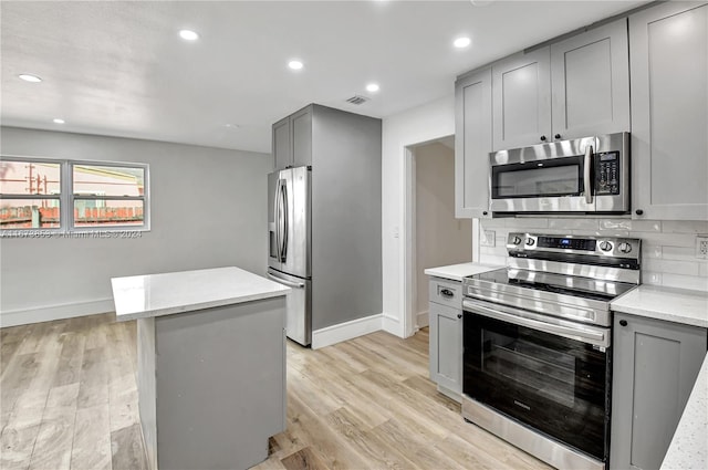 kitchen featuring gray cabinets, light hardwood / wood-style floors, and stainless steel appliances