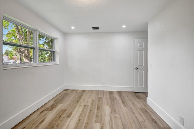 unfurnished room featuring vaulted ceiling and light wood-type flooring