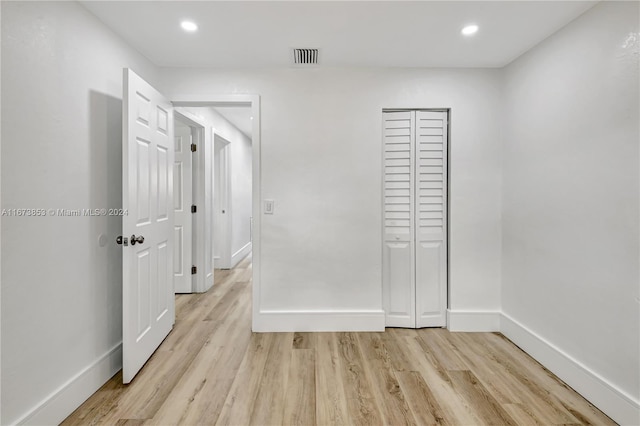 unfurnished bedroom featuring light wood-type flooring and a closet