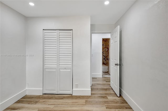 unfurnished bedroom with light wood-type flooring and a closet