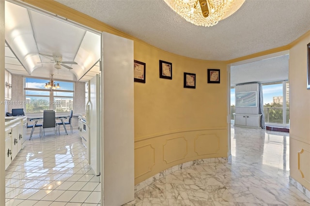 corridor featuring ornamental molding, a textured ceiling, and floor to ceiling windows