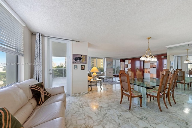 dining space with a notable chandelier, a textured ceiling, a wall of windows, and plenty of natural light