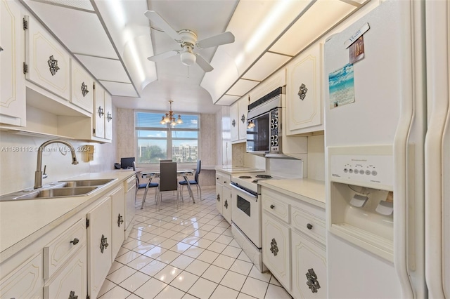 kitchen with white appliances, light tile patterned flooring, sink, ceiling fan with notable chandelier, and white cabinets