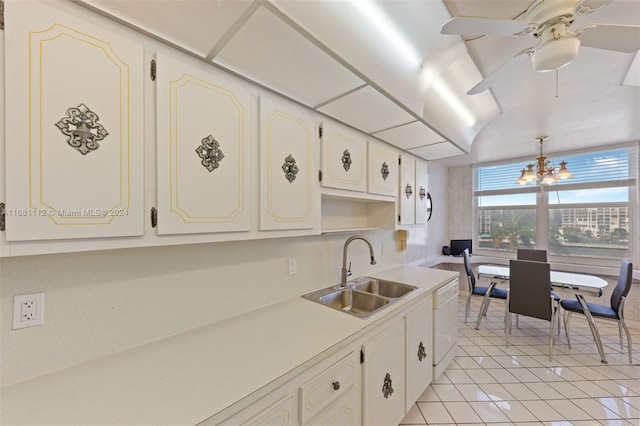 kitchen featuring dishwasher, sink, light tile patterned flooring, decorative light fixtures, and white cabinets