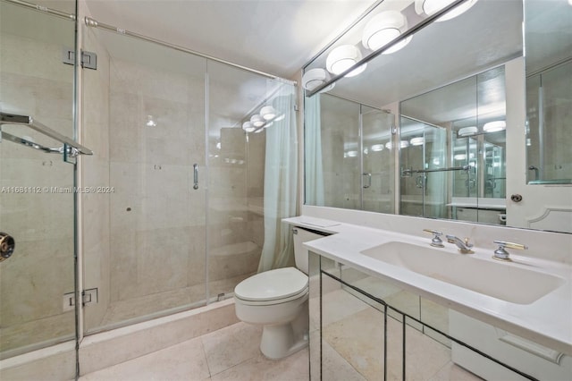 bathroom with vanity, toilet, tile patterned floors, and a shower with door